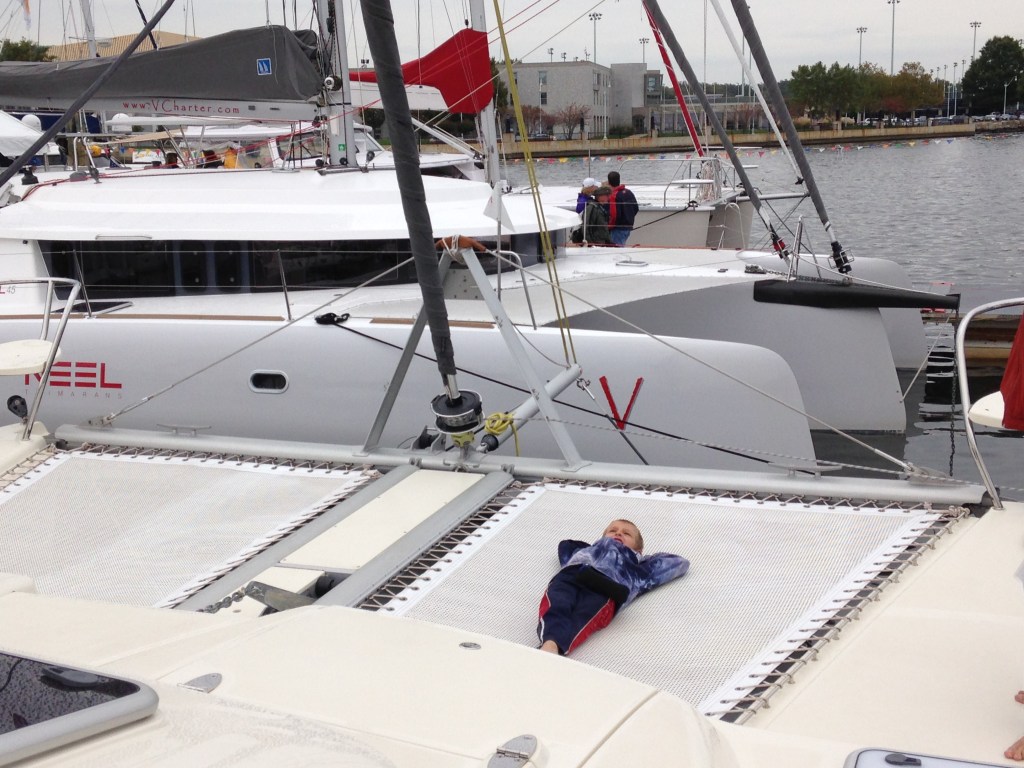 Our son Paul lying on his back on a trampoline on a catamaran at the Annapolis Boat Show 2015.