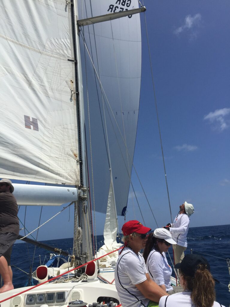 Round Antigua Race: Spinnaker on the SV Spirit of Juno is being managed by the man to the right of the photo, wearing a cream-colored hat