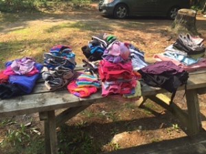 A few days of clean laundry, folded on a picnic table.