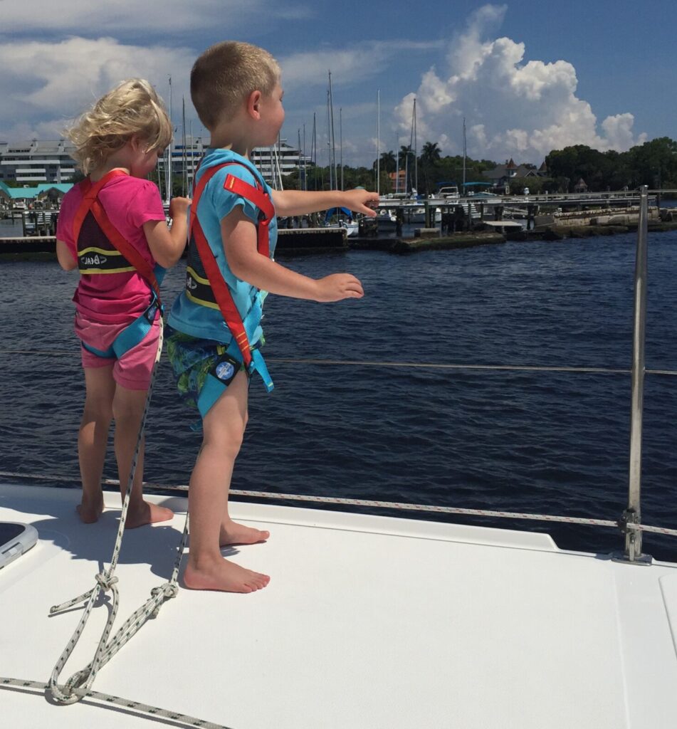 Living on a sailboat with kids: Henry and Karen (age 4) are tethered to a safety line.