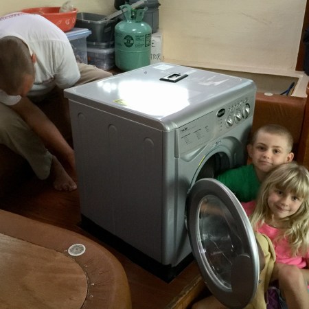 Kids on a St Francis 50 catamaran with a Splendide washing machine in the saloon.