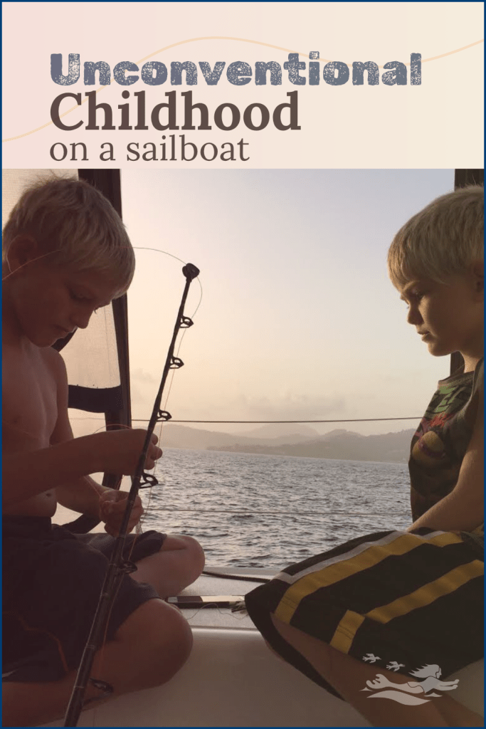 Boat kids, Paul and Henry, focused on a fishing rod in the cockpit of our St. Francis 50 catamaran, SV Aphrodite.