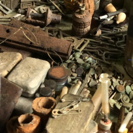 Glasses sit atop other World War II artifacts including a glass syringe.