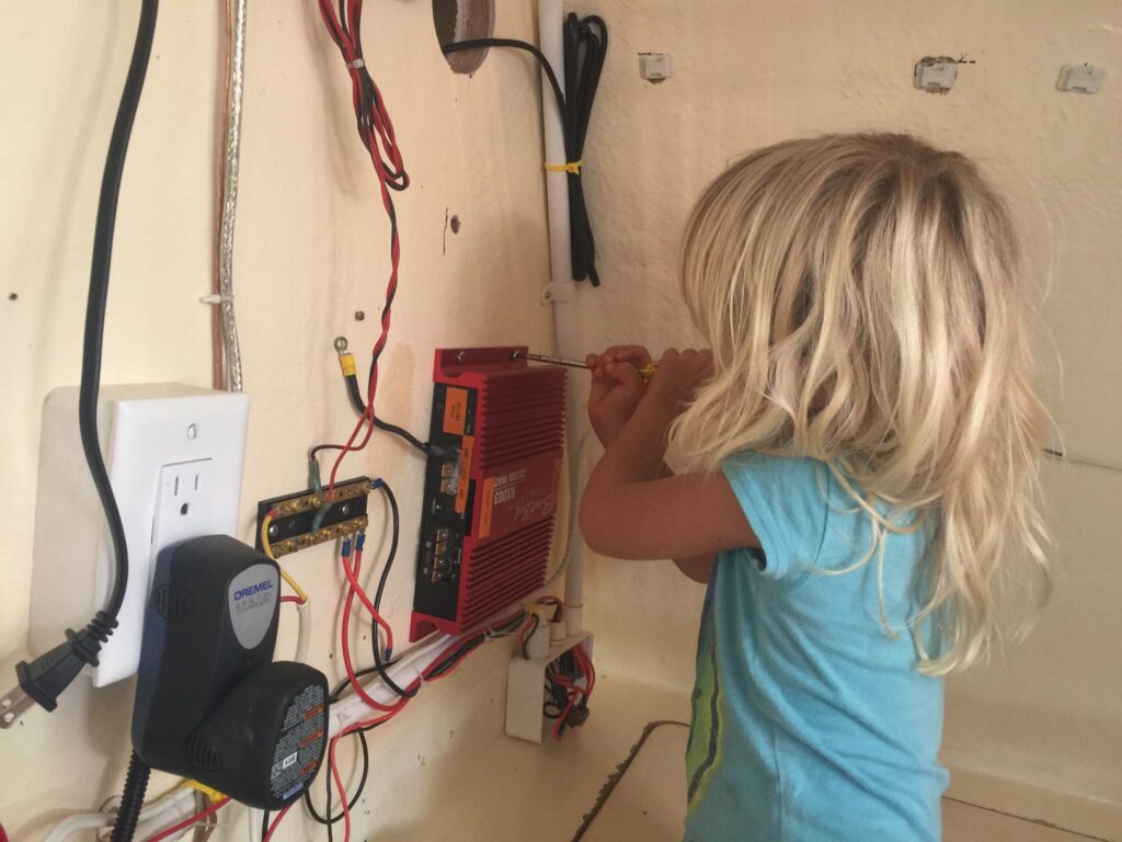 Karen age 4, working with a screwdriver behind the television.