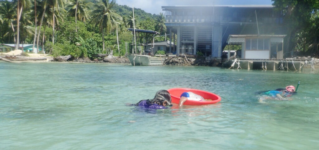 Subsistence fishing: Young girls in Chuuk, Micronesia snorkel to gather sea cucumbers