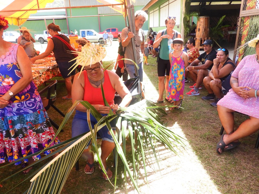 A woman weaves in a colorful market scene at Hiva Oa, French Polynesia.