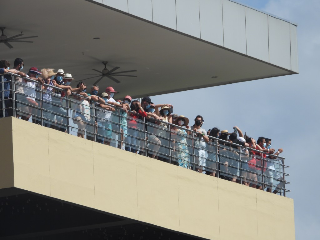 Tourists watch us as we cross through the Panama Canal in December 2021. They are wearing masks because it is just post-COVID.