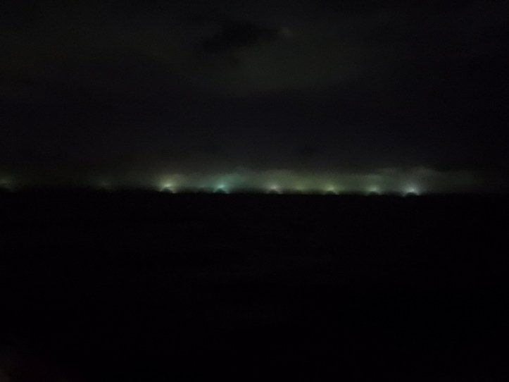 Fishing fleet near the Galapagos appears as lights on the horizon.