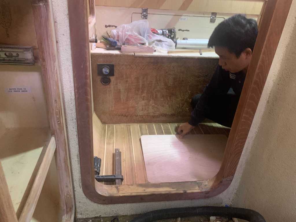 Port Aft Cabin flooring installation: Chin from Eastbay woodwork cutting the flooring for the aft port berth on SV Aphrodite, a St Francis 50 catamaran.