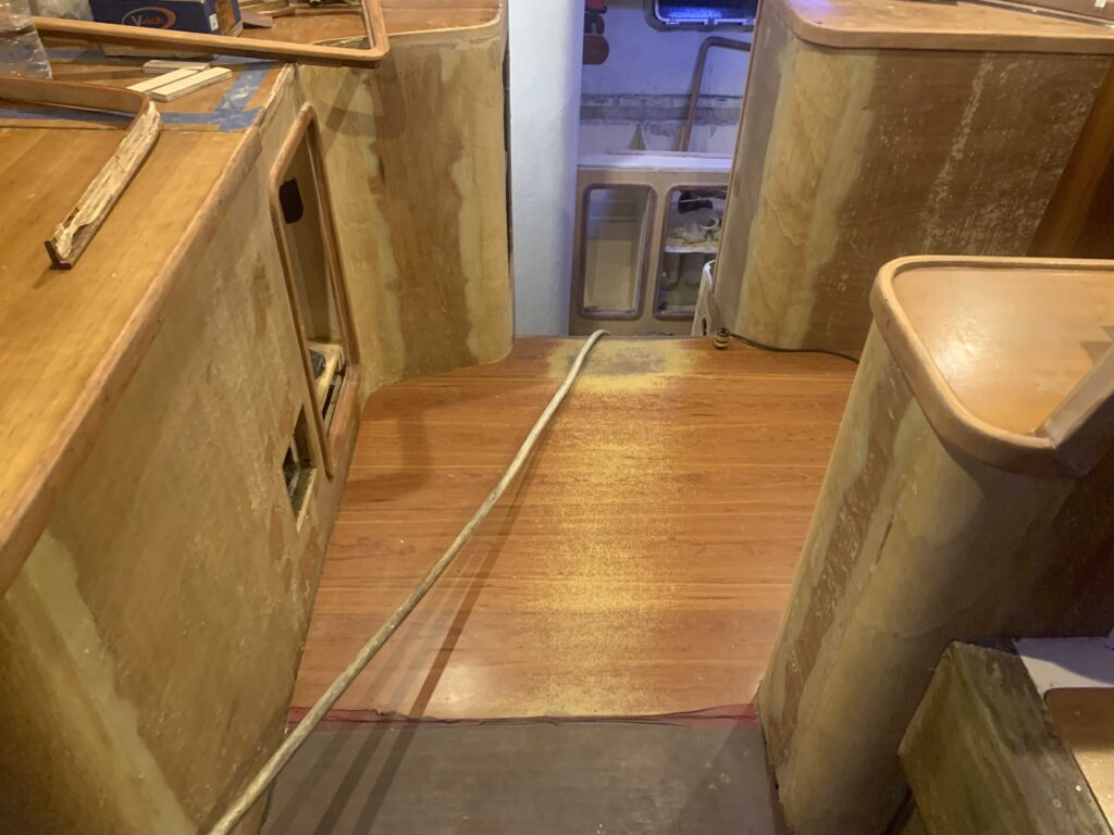 As part of our boat woodwork refit, veneer in the navigation area is removed and a well-worn patch of linoleum is visible. This path of floor overlooks the galley.
