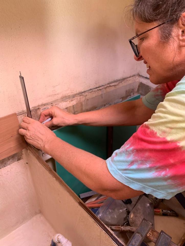Lorraine Escher measures for gallery countertop, unskilled and unhappy about the task.
