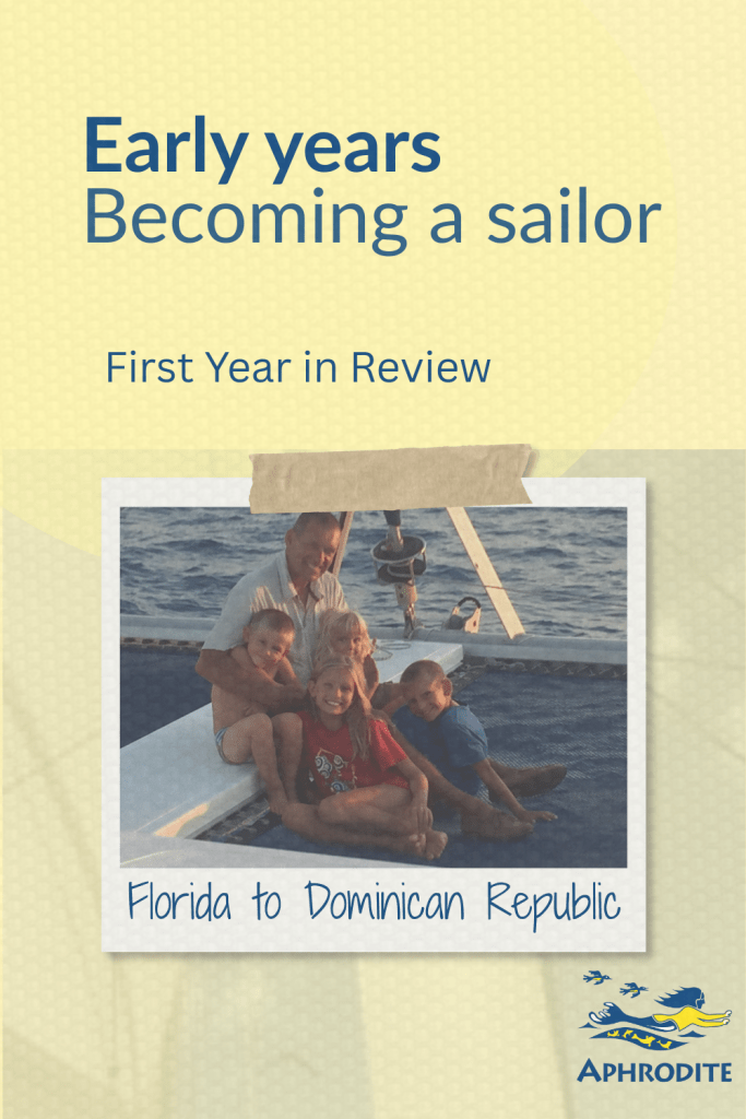 RIck with our four children sitting on the bow of our catamaran, SV Aphrodite.