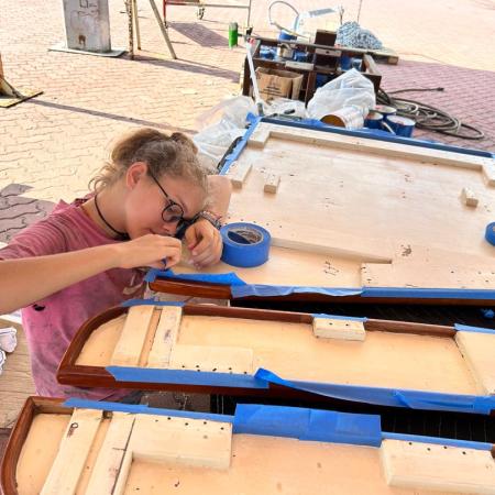 Karen painting the underside of our saloon table at Lunas Shipyard in Langkawi, Malaysia.
