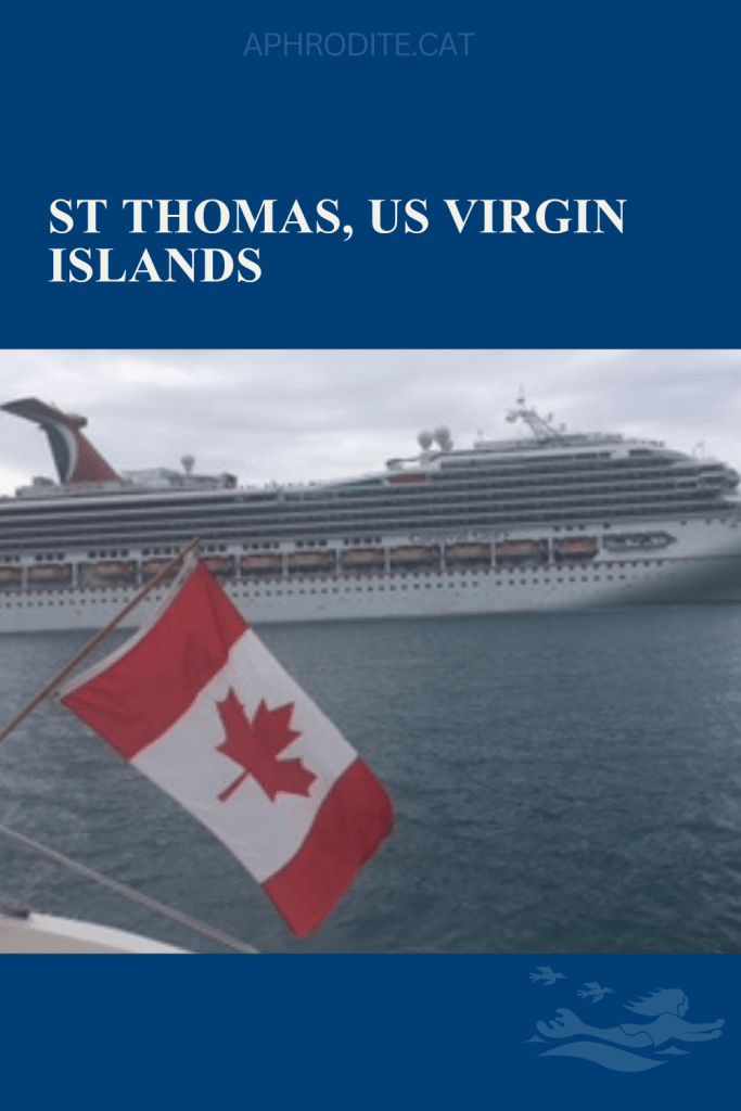 In the USVI with ta cruise ship in the background and the Canadian flag in the foreground as it flies from the back of our catamaran, SV Aphrodite.
