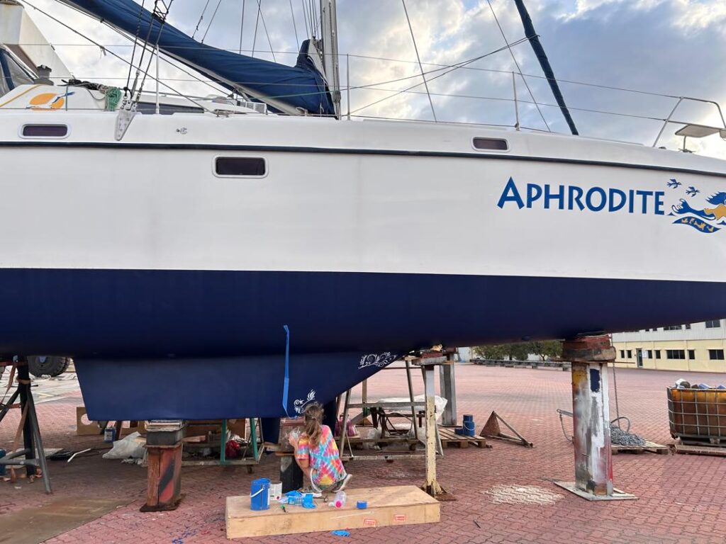 Keel art: Starboard keel as Karen began the classical scrollwork for her sailboat keel painting project on our St. Francis 50 catamaran.