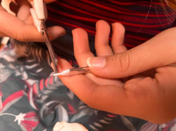 Karen trimming a paintbrush to paint a whaleshark on the keels of our St. Francis 50 catamaran, SV Aphrodite.