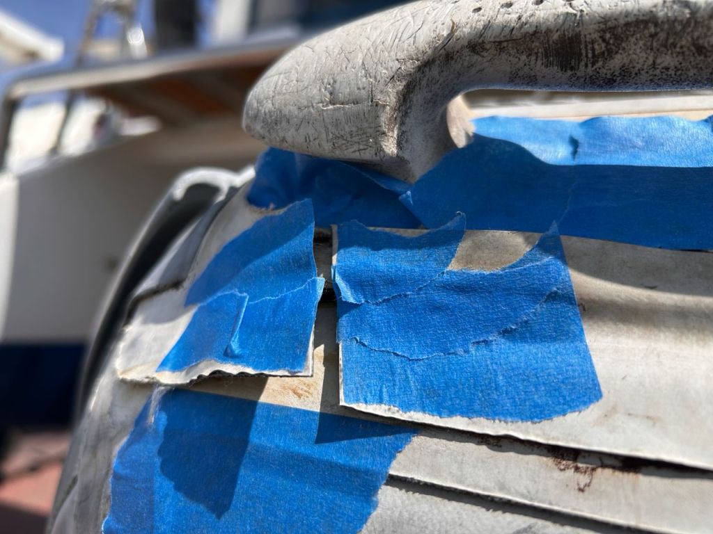 Close-up on the blue tape on a dinghy handle during a repair