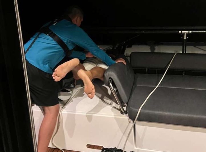 Paul Escher holding Dave Houston's feet from SV O'Vive during a dinghy rescue while underway from the Bahamas to Panama