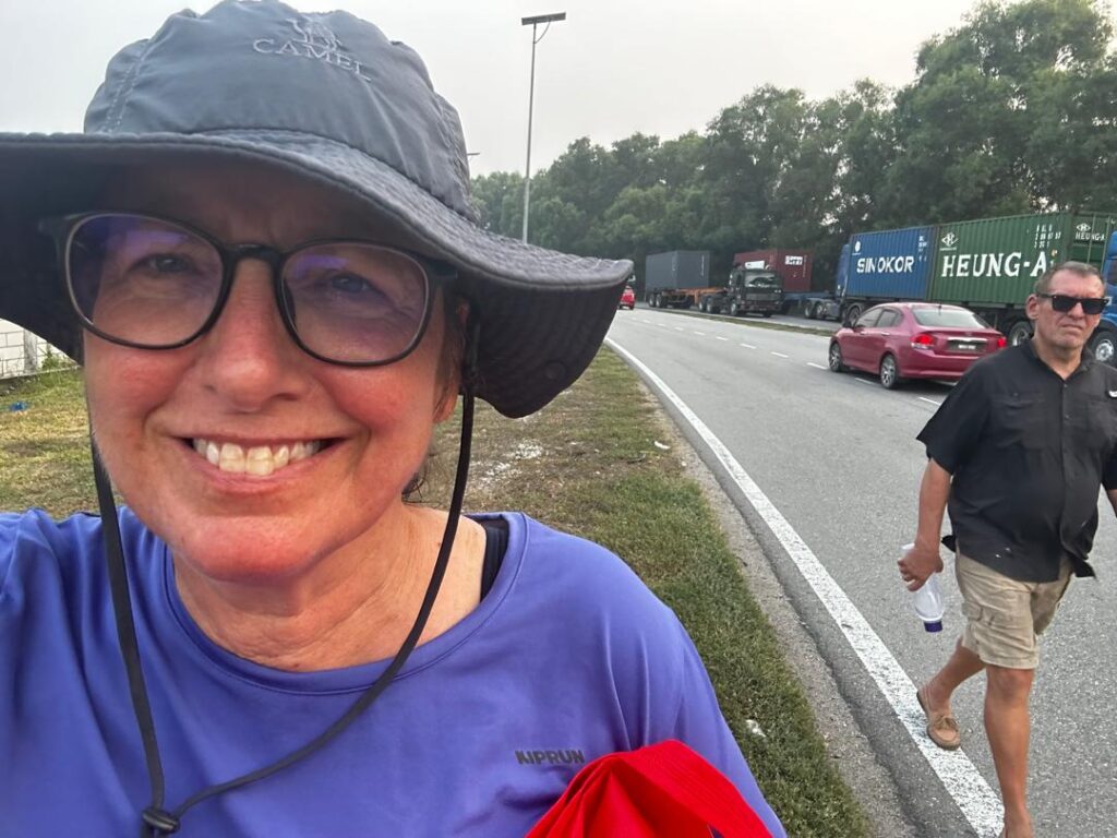Lorraine and Rick walking along a highway in Pulau Idah